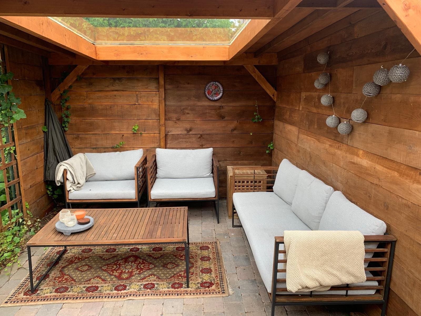 Overdekte veranda met loungebank, daklicht en sfeerverlichting